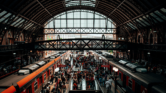 Das Bild zeigt einen Bahnhof mit viele Personen.